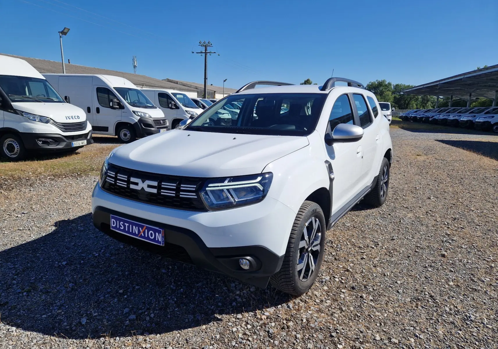Dacia Duster 4x4 blanc en 3/4 avant droit, avec jantes alu 17 pouces et calandre noire distinctive.