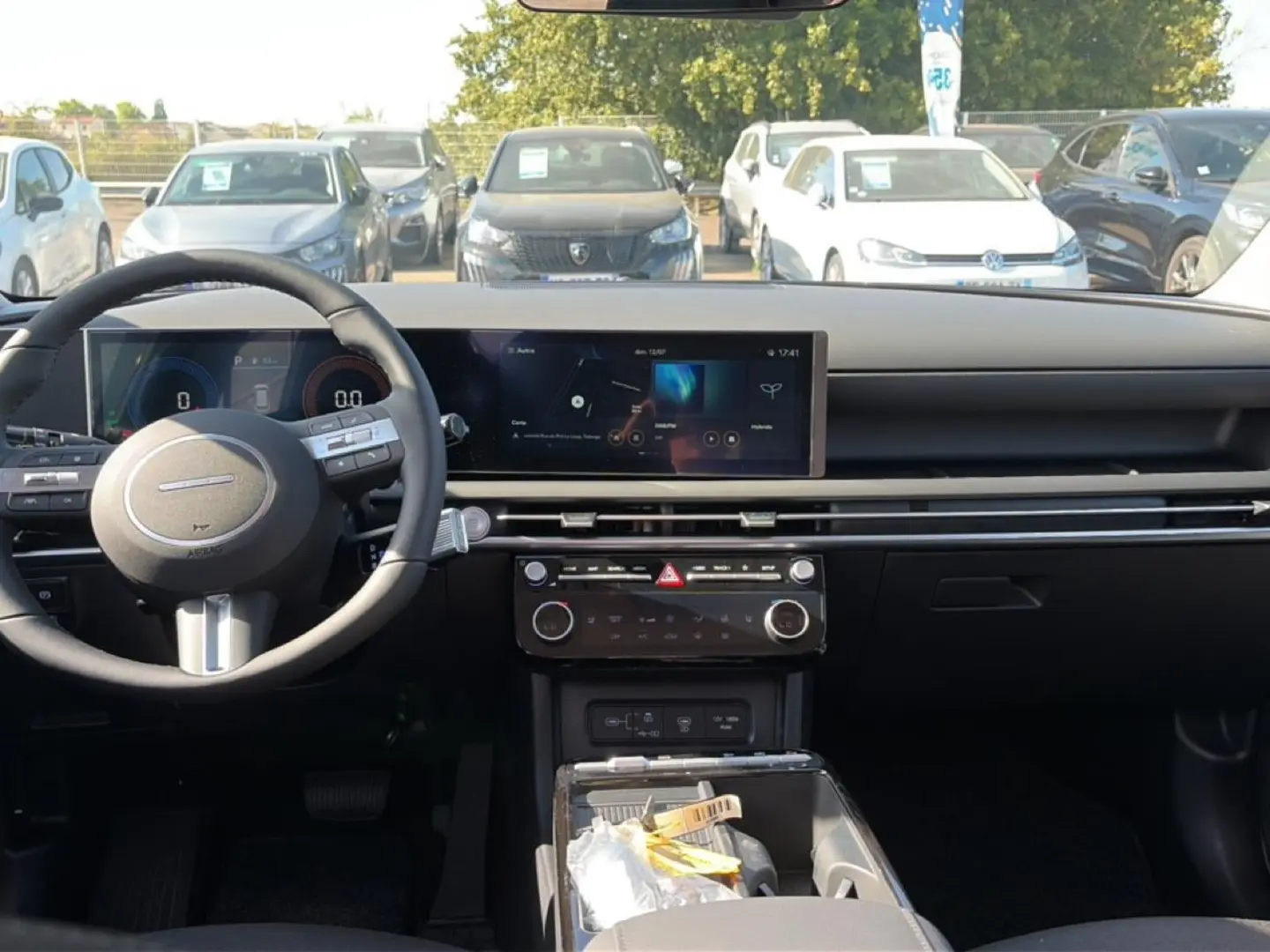 Vue intérieure frontale du tableau de bord et volant cuir noir du Hyundai Tucson 2026, avec écran tactile large et commandes au volant.