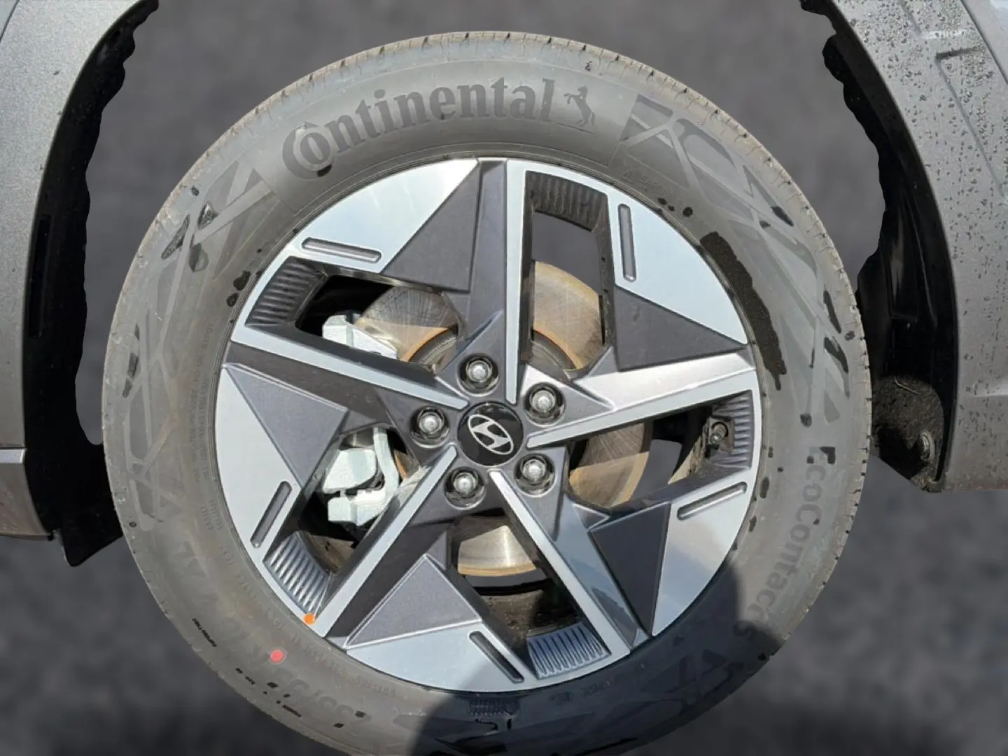 Gros plan sur la jante alu 18 pouces gris ecotronic du Hyundai Tucson 1.6 t-gdi 239 hybrid intuitive avec logo Hyundai central.