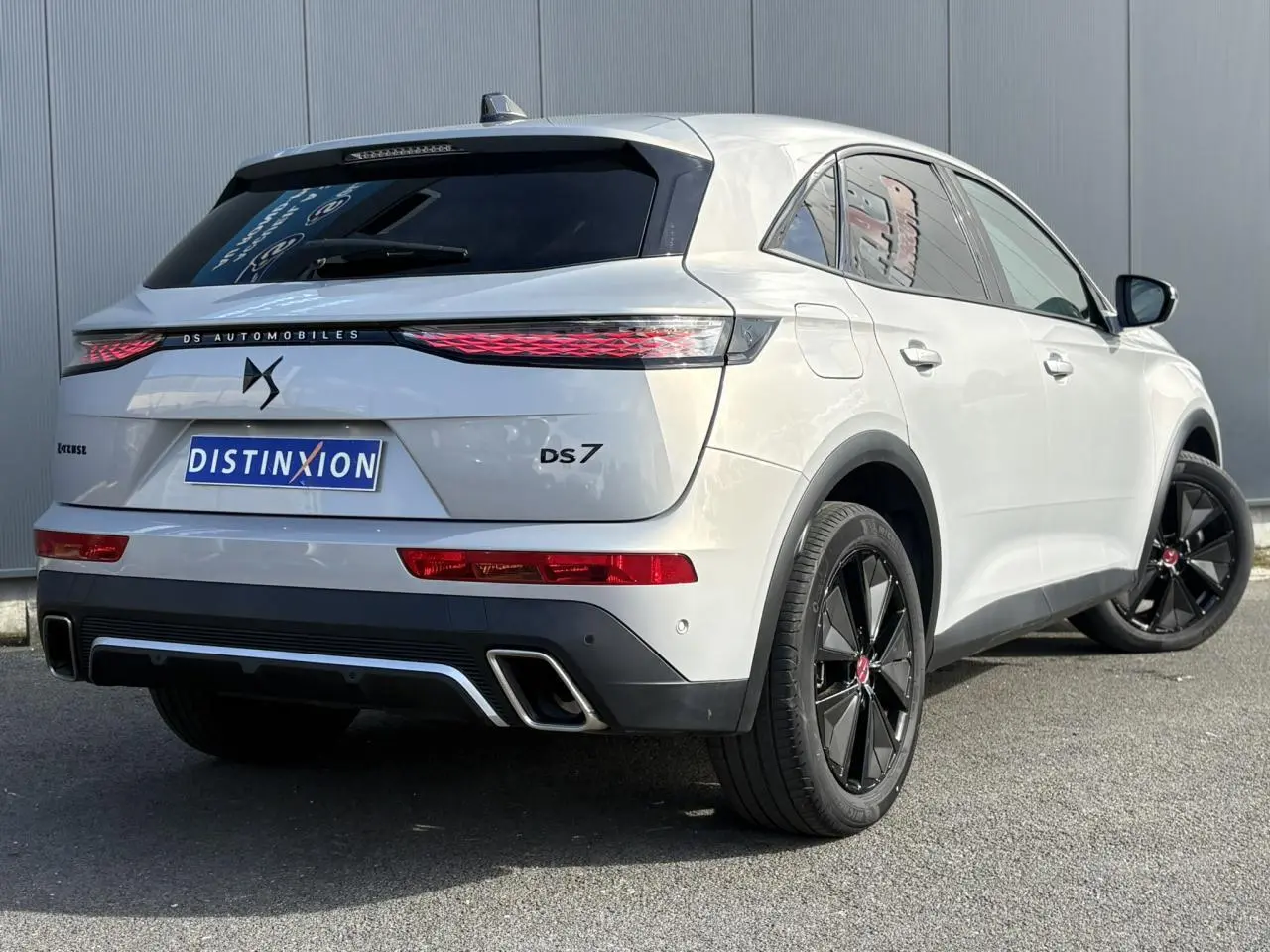 Vue 3/4 arrière droite du DS7 1.6 E-Tense 225 Cristal Pearl avec jantes noires et feux arrière LED 3D.