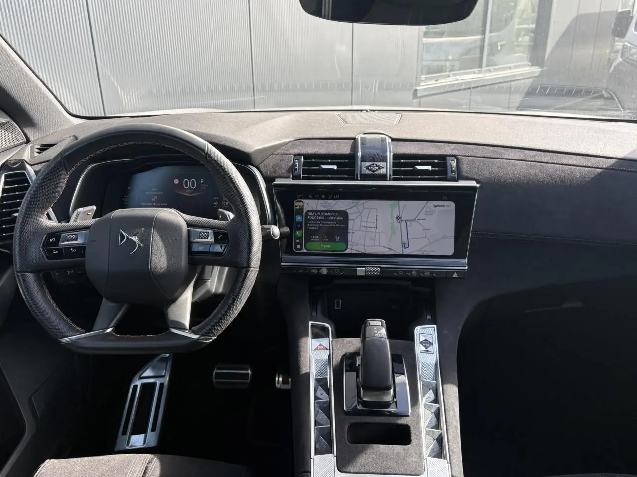 Vue intérieure avant du DS7 2024 avec tableau de bord et console en Alcantara noir profond et écran tactile central.