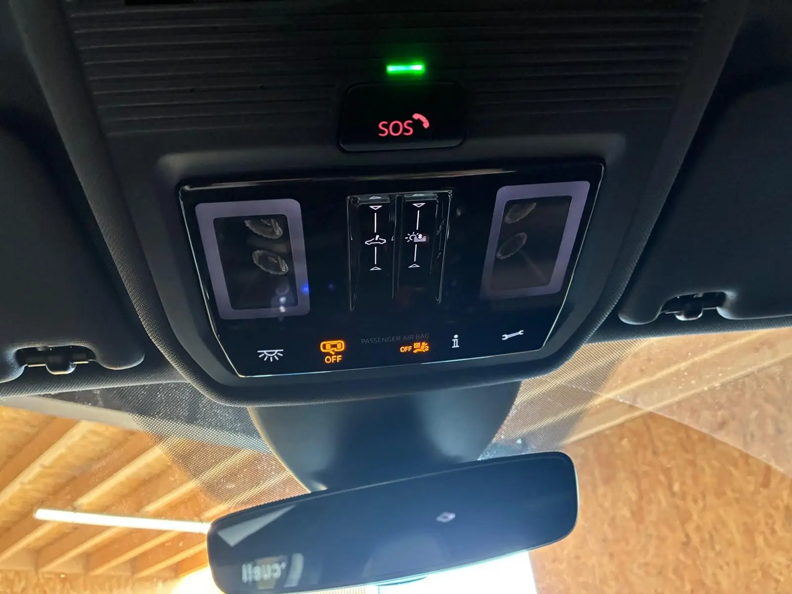 Vue en gros plan du panneau de commandes au plafond intérieur du CUPRA Formentor gris 2024, avec bouton SOS et voyants lumineux.