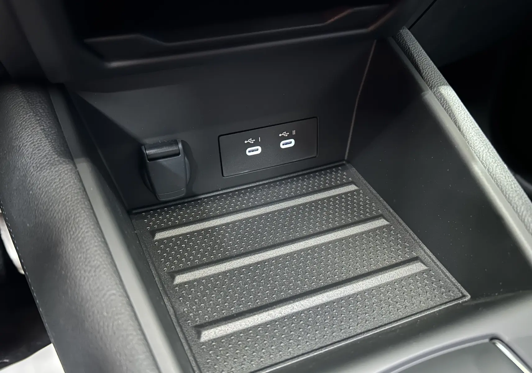 Gros plan de la console centrale du Renault Captur blanc nacré 2026, montrant les ports USB-C doubles et un espace de rangement noir.