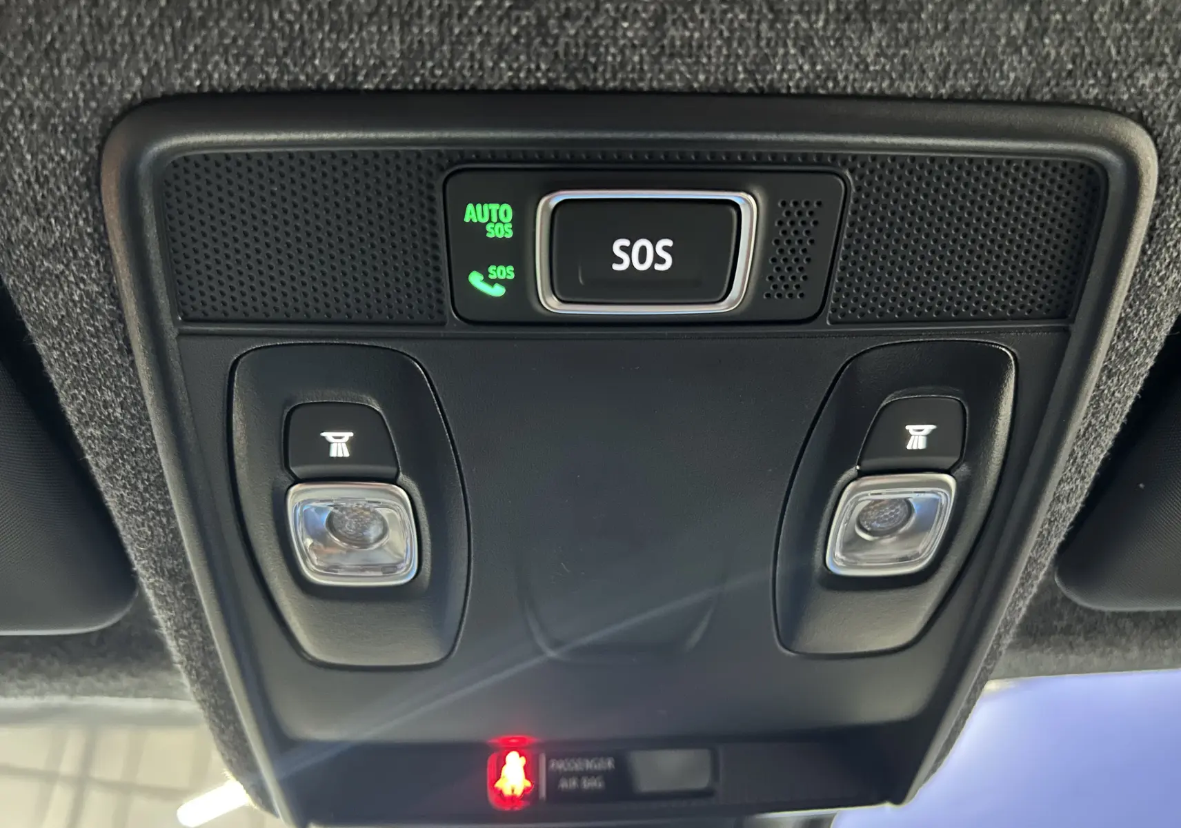 Vue en contre-plongée du panneau de commandes au plafond du Renault Captur blanc nacré, avec bouton SOS et éclairages intégrés.