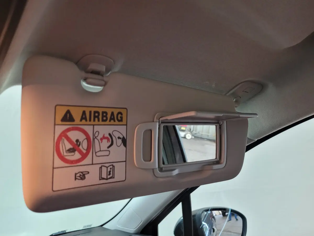 Miroir de courtoisie ouvert sur pare-soleil côté conducteur dans l'habitacle gris clair d'une Renault Clio 2025.