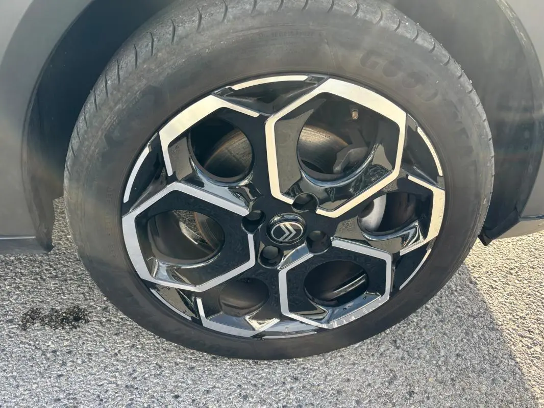 Gros plan sur la jante alliage noire et argentée de 17 pouces d'une Citroën C3 bleu 2025.