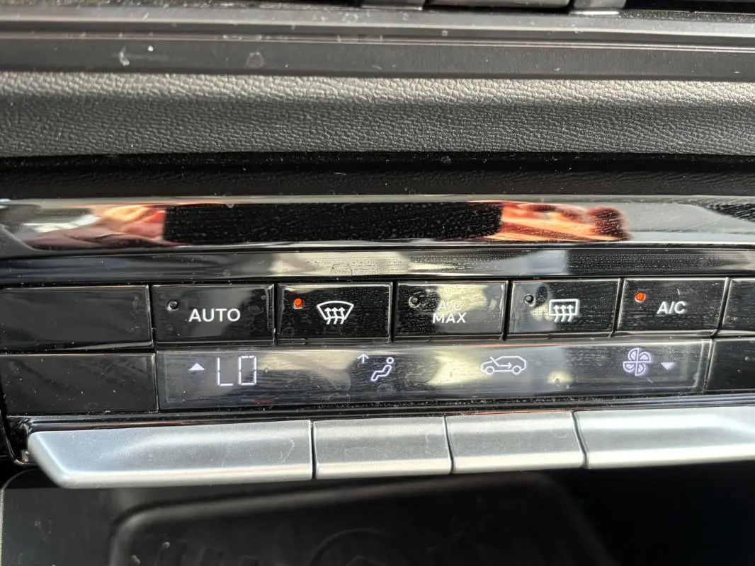 Gros plan sur la console de climatisation automatique de la Citroën C3 Turbo 100 ch, avec affichage digital et boutons noirs brillants.