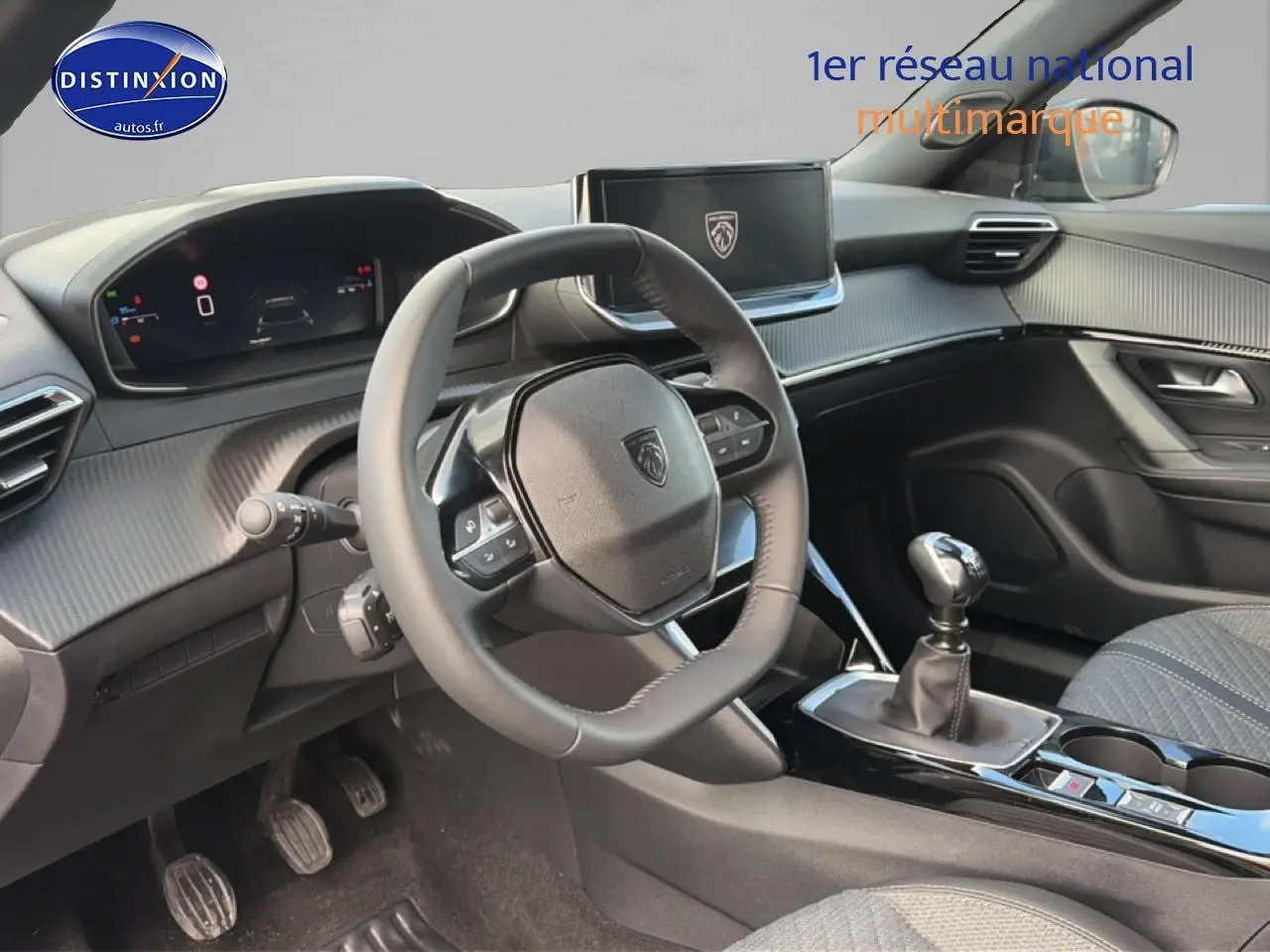 Vue intérieure avant gauche du Peugeot 2008 1.2 100 allure 2025, volant multifonction et levier de vitesse manuel visibles.