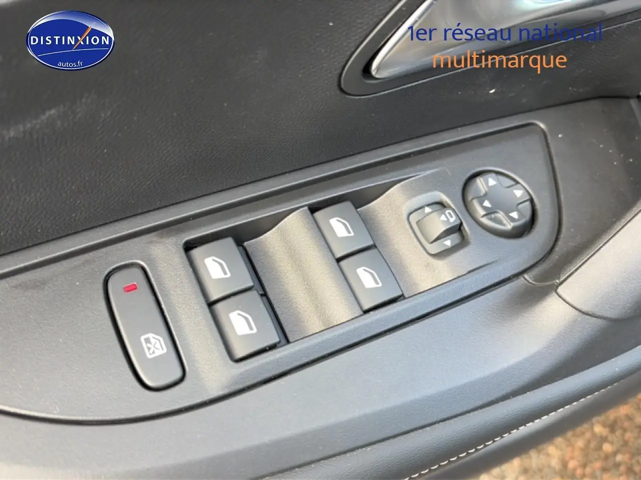 Gros plan sur les commandes de lève-vitres et réglage des rétroviseurs côté conducteur d'une Peugeot 2008 noire.