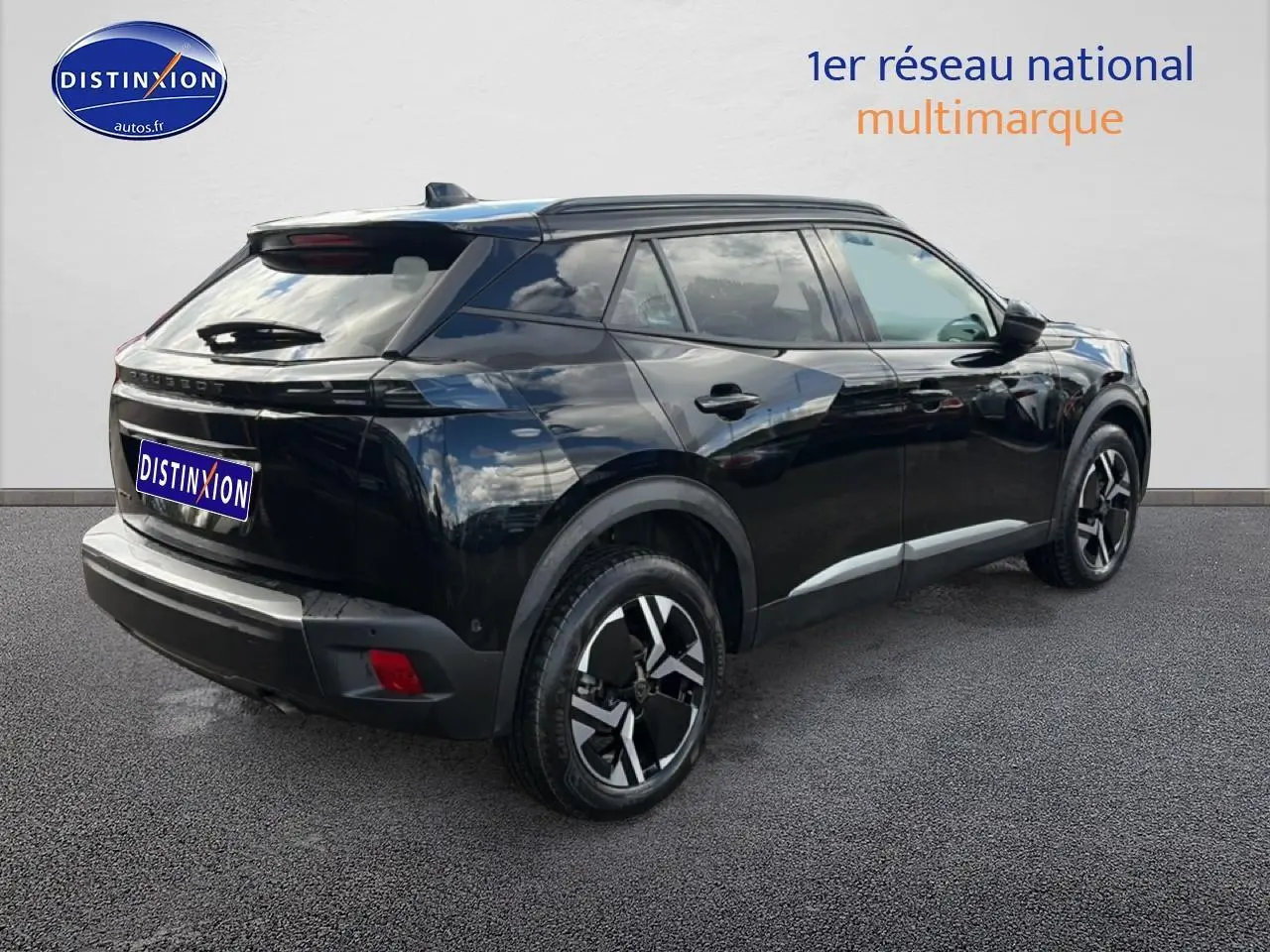 Vue 3/4 arrière droite d’un Peugeot 2008 noir avec jantes alu et feux arrière LED sur fond neutre.