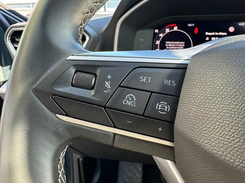 Gros plan sur les commandes au volant côté gauche du SEAT LEON ST 2.0 TDI 115ch STYLE XL 2025, intérieur noir.