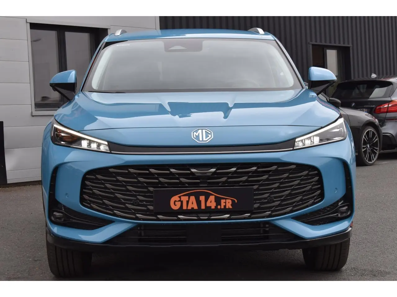 Vue frontale du MG Motor EHS 1.5 Hybrid+ bleu métallisé avec large calandre noire et phares LED fins.