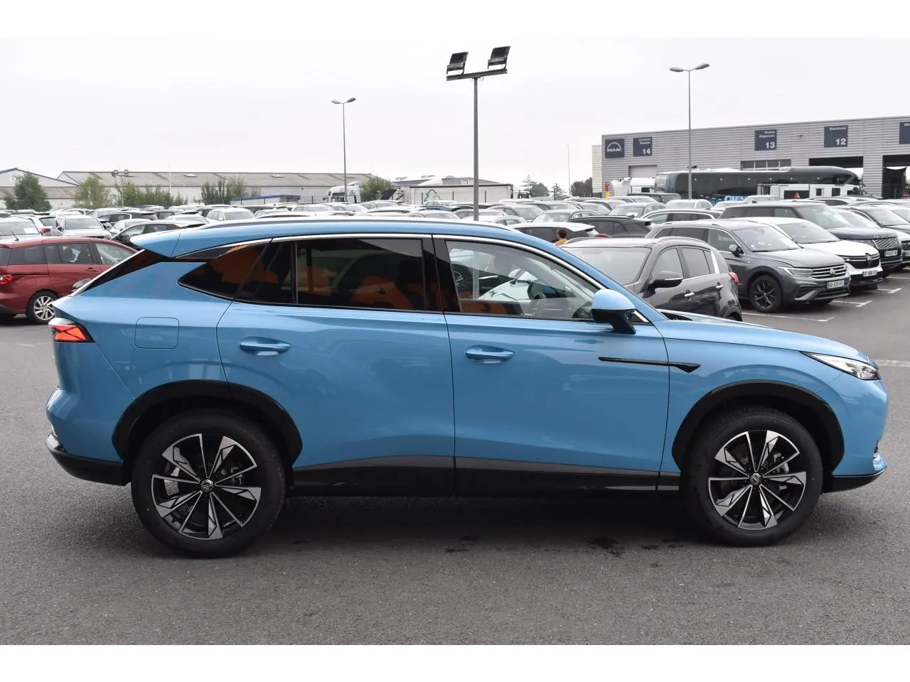 Vue de profil côté gauche d’un MG Motor EHS 1.5 Hybrid+ bleu métallisé avec jantes alliage 19 pouces.