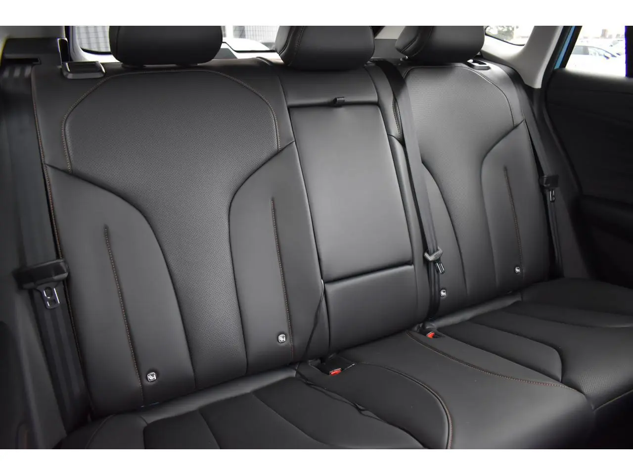 Vue rapprochée des sièges arrière en similicuir noir avec surpiqûres marron du MG MOTOR EHS 1.5 Hybrid+ 224 ch Luxury 2026.