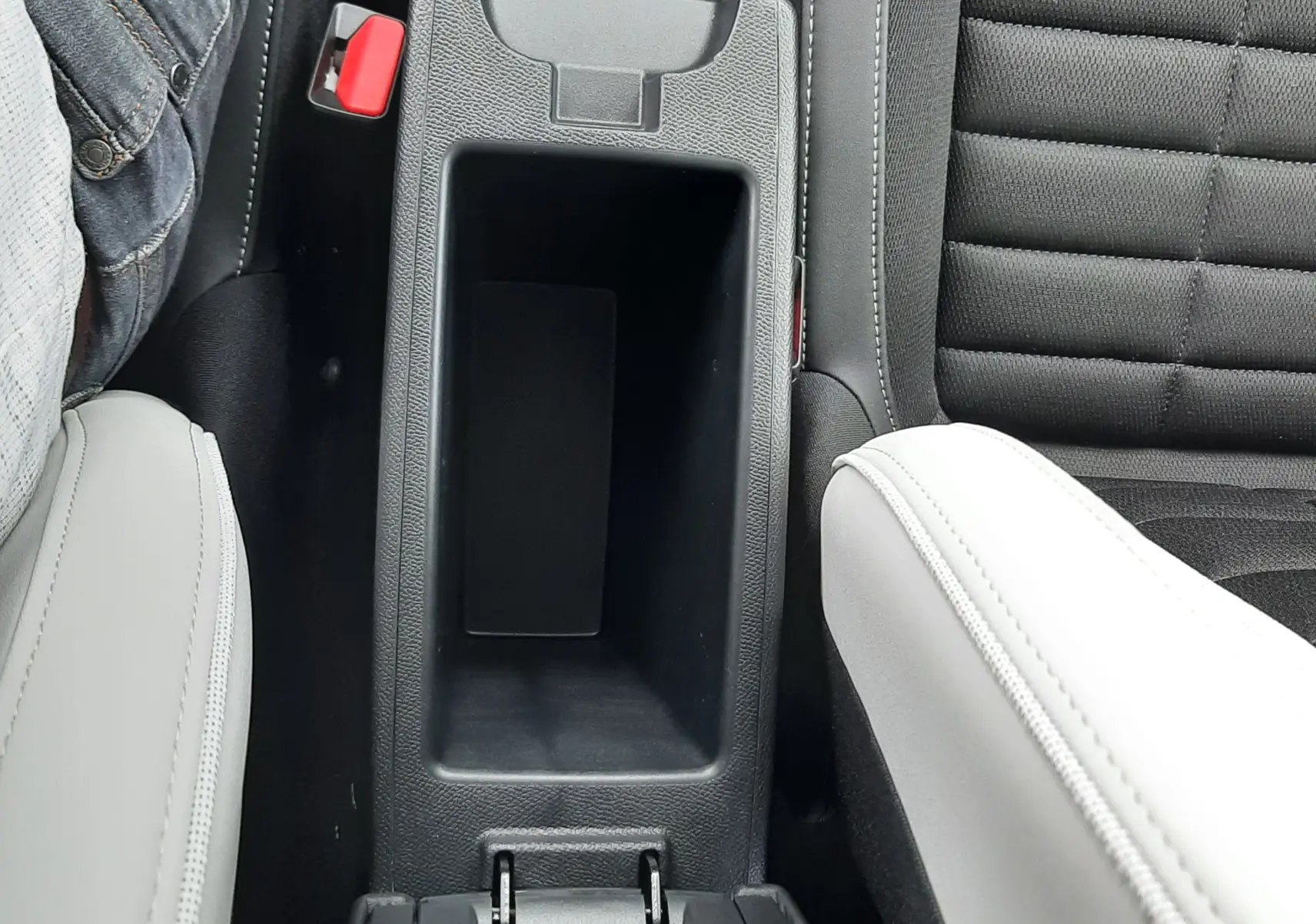 Vue plongeante sur la console centrale noire entre sièges gris clair et tissu noir à surpiqûres du Citroën C3 Aircross 2026.
