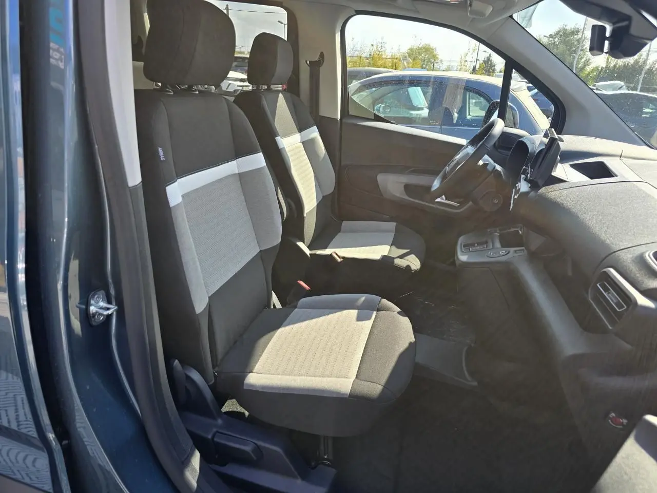 Vue intérieure côté conducteur du Citroën Berlingo bleu Kiama, montrant les sièges avant et le tableau de bord.