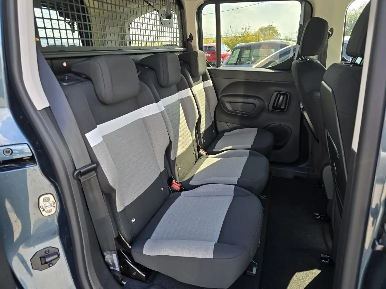 Vue intérieure côté droit des trois sièges arrière gris et noirs du Citroën Berlingo III M 2025 bleu Kiama métal.