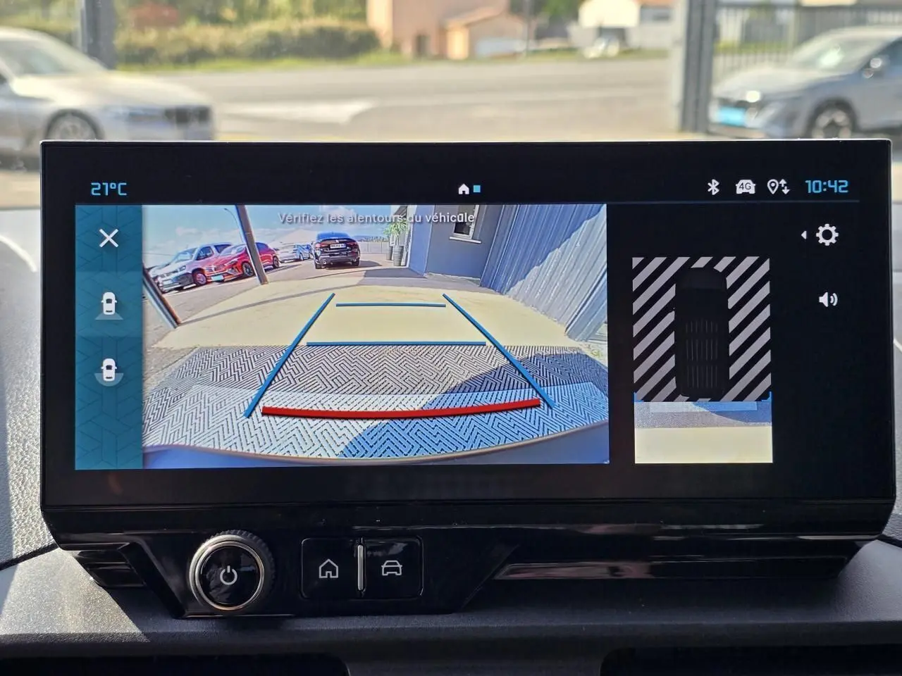 Écran central du Citroën Berlingo 2025 montrant la caméra de recul avec vue arrière et lignes de guidage colorées.