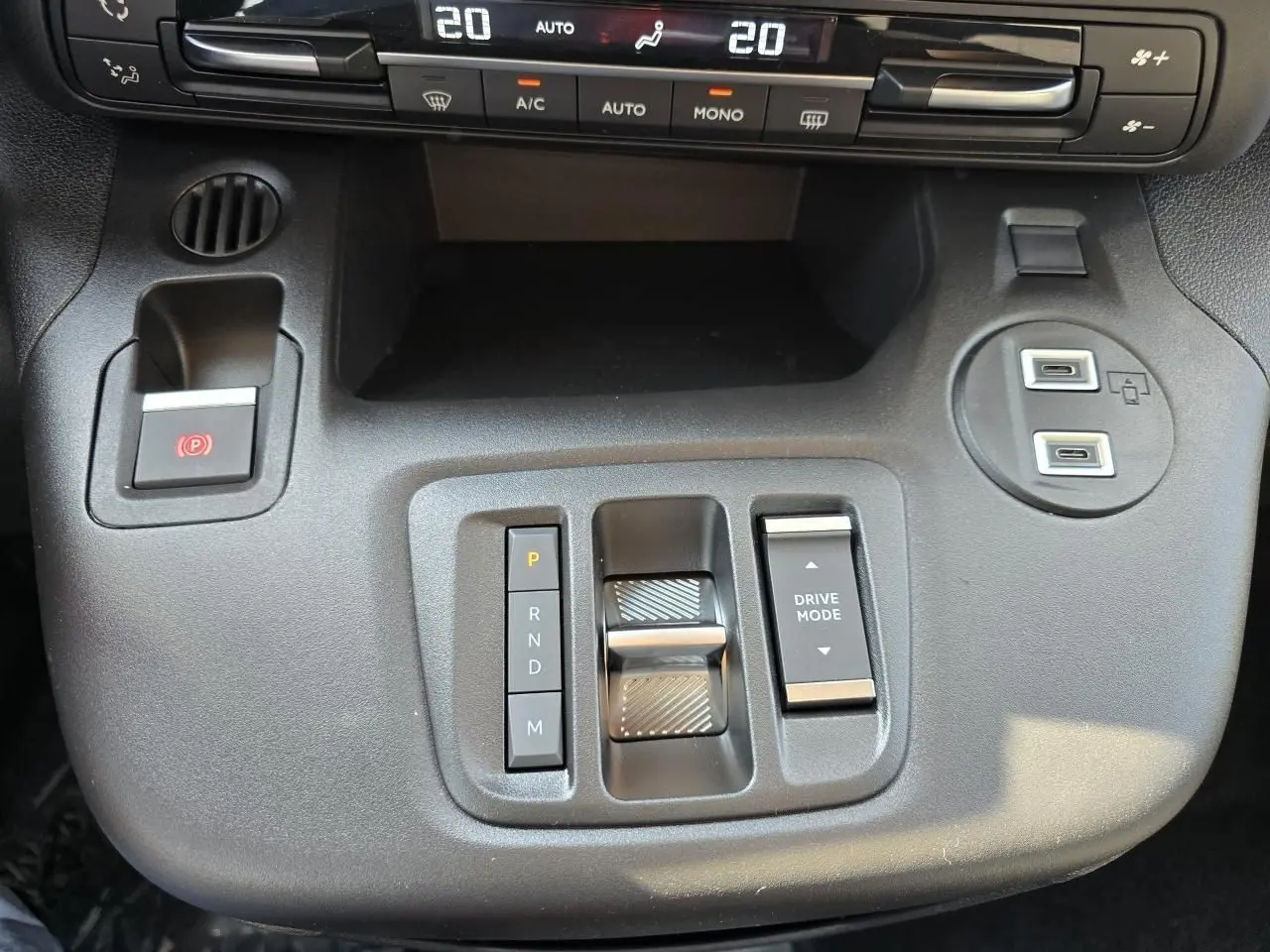 Vue rapprochée de la console centrale du Citroën Berlingo 2025, avec commandes de boîte auto et climatisation digitale.