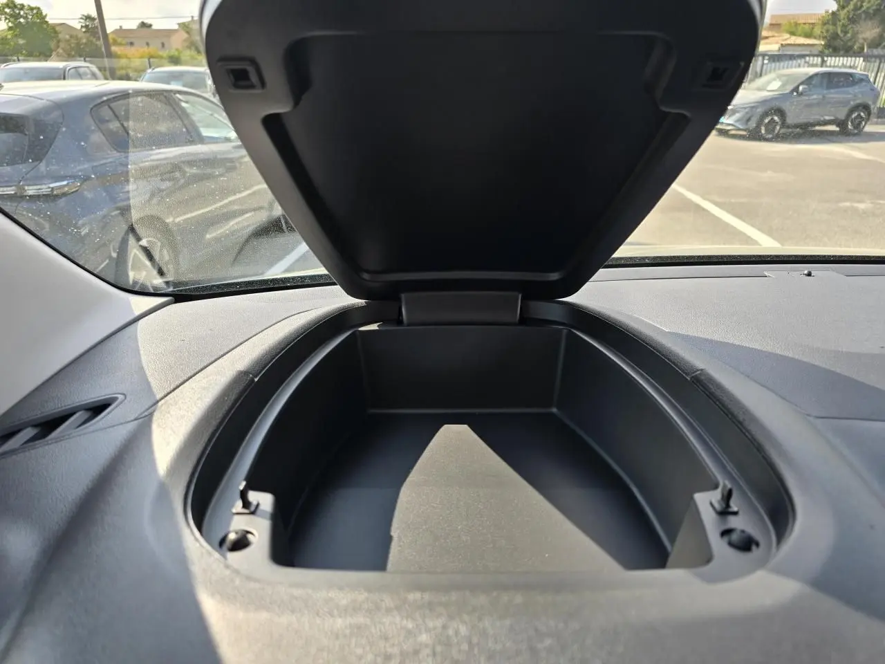 Rangement ouvert sur le tableau de bord du Citroën Berlingo bleu Kiama, vue intérieure avant du véhicule.