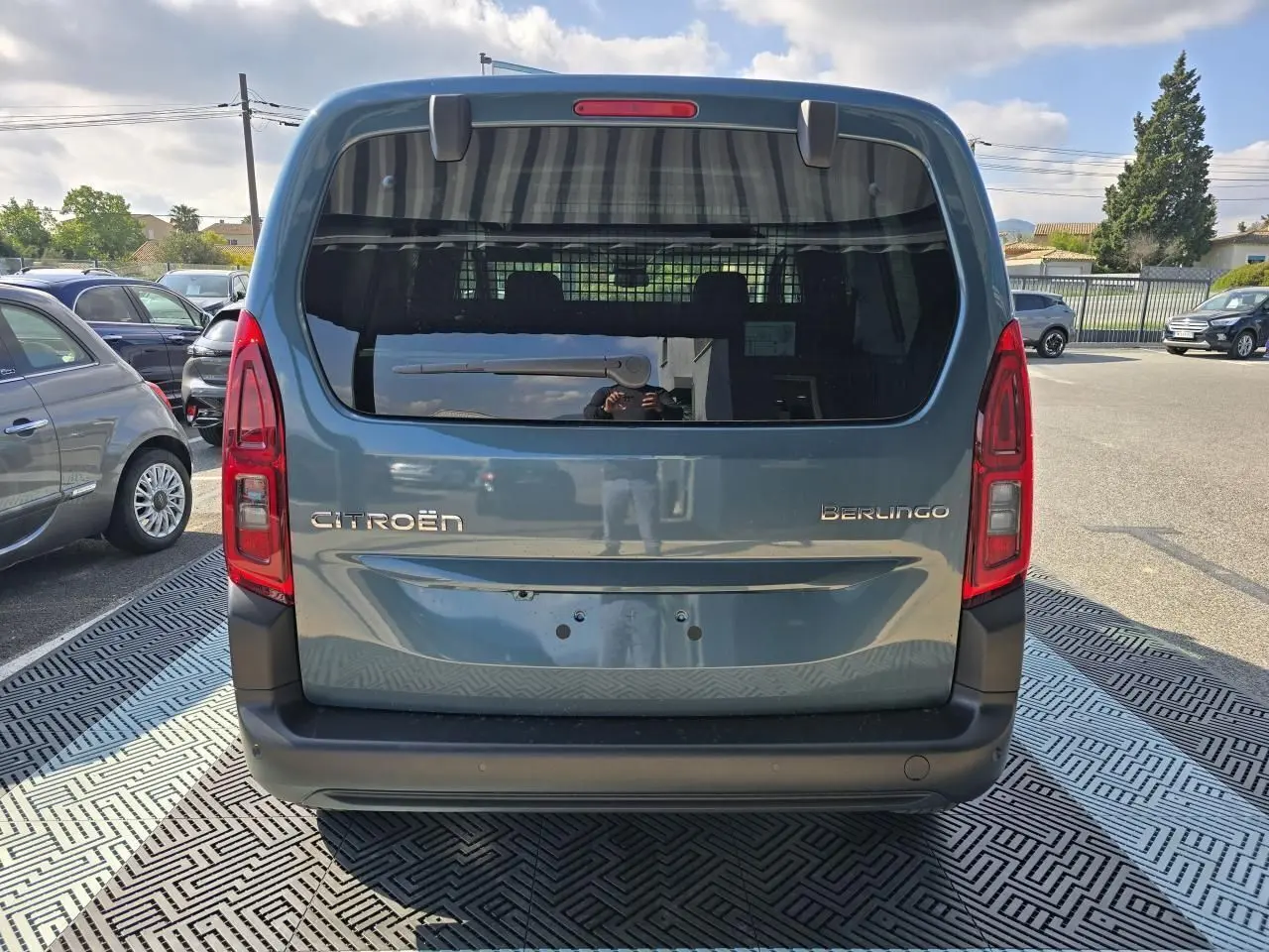 Vue arrière d'un Citroën Berlingo III bleu Kiama métallisé avec vitres arrière teintées et hayon large.