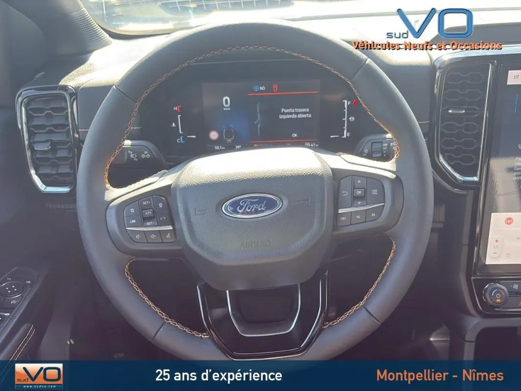 Vue rapprochée du volant multifonctions du Ford Ranger 2025, mettant en valeur les commandes intégrées et l'écran digital derrière.