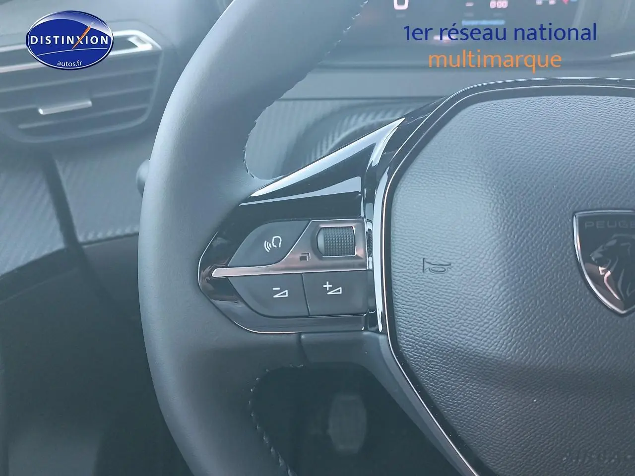 Gros plan sur le volant multifonction noir du Peugeot 2008 gris Artense, avec commandes audio intégrées.