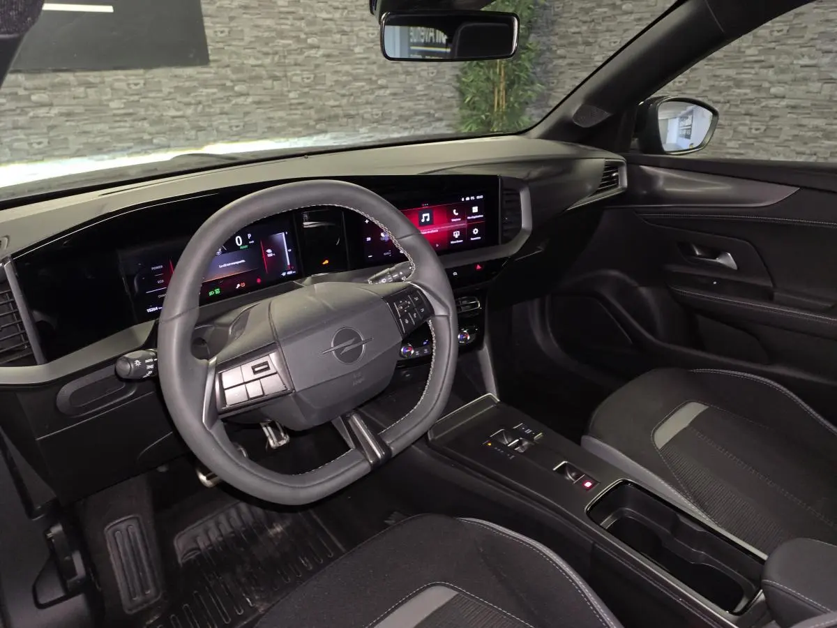 Vue intérieure côté conducteur de l'Opel Mokka-e 2025 noire, avec tableau de bord digital et volant multifonction.
