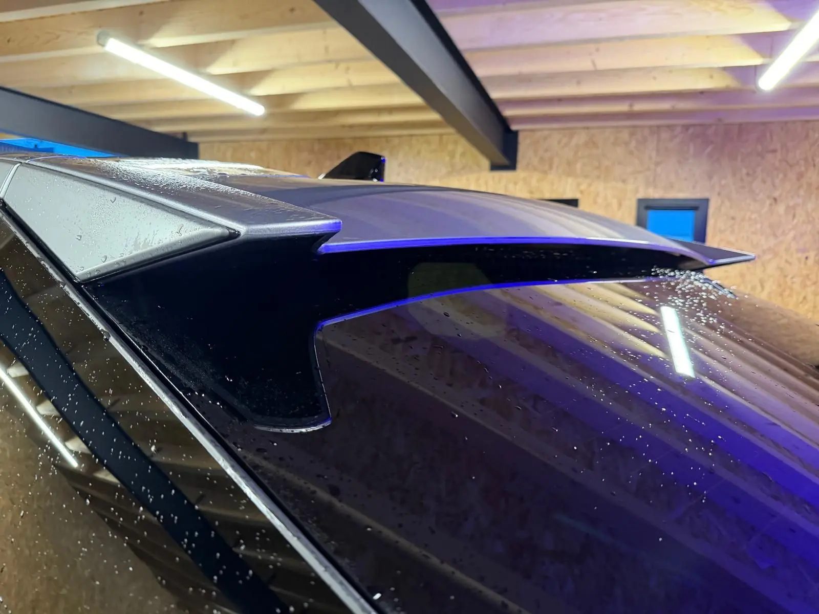 Détail de l'aileron arrière gris du Peugeot 3008 1.2 Hybrid 136 Allure, vu de près sous un éclairage intérieur.