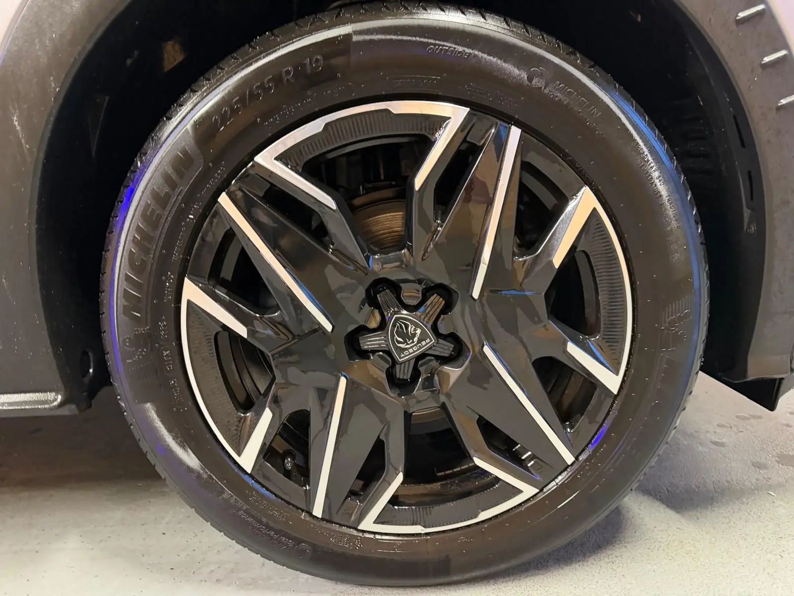 Gros plan sur la jante noire et argentée du Peugeot 3008 gris 1.2 HYBRID 136 ALLURE, roue avant droite.