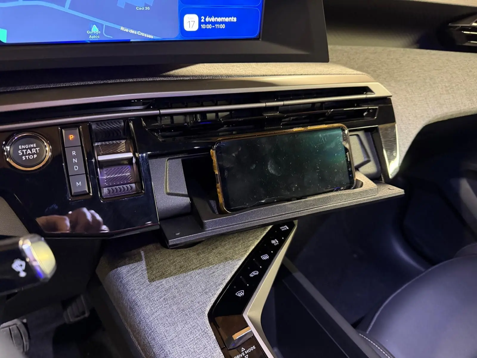 Détail de la console centrale du Peugeot 3008 gris 2025, avec écran tactile et rangement pour smartphone intégré.