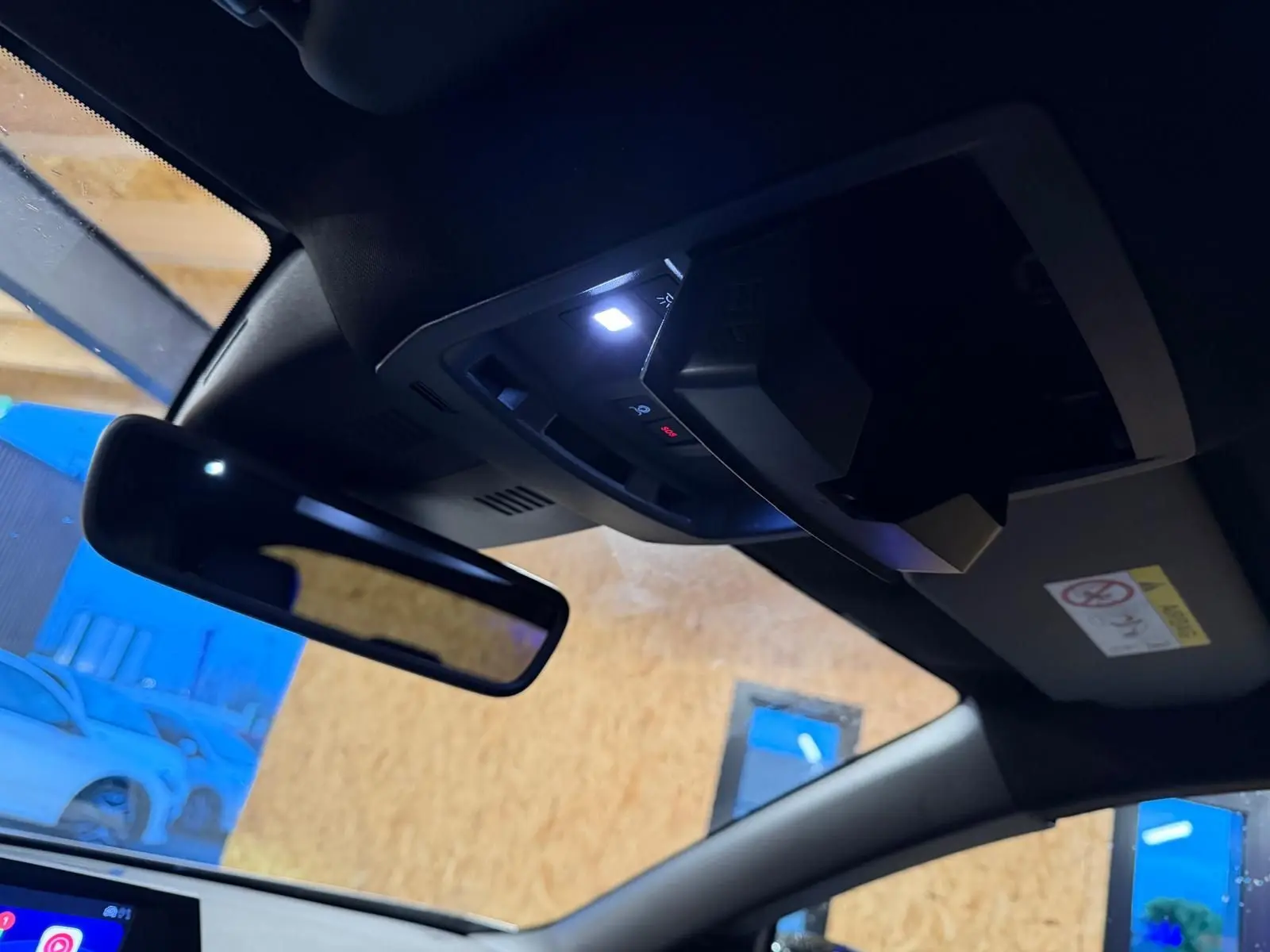 Vue intérieure du toit d’un Peugeot 3008 gris 2025, avec miroir de courtoisie et éclairage LED activé.