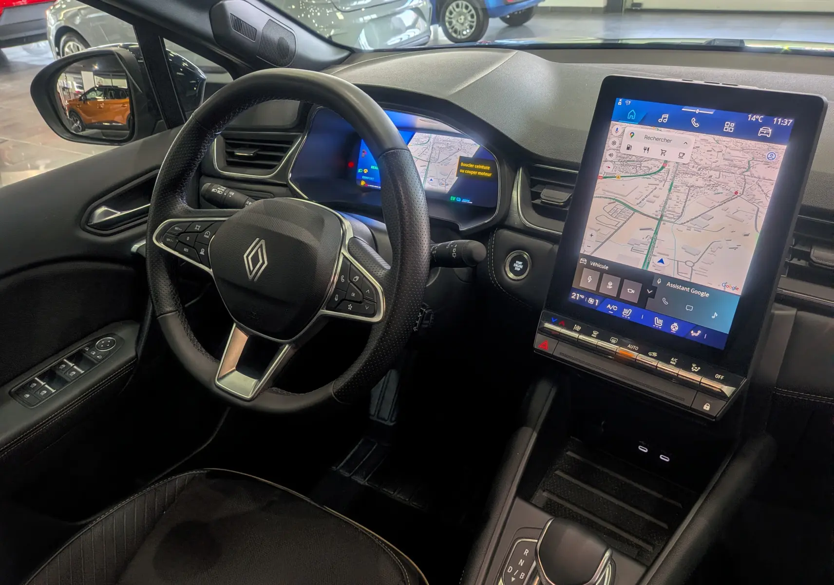 Vue intérieure côté conducteur du Renault Symbioz 2025, tableau de bord avec écran tactile vertical et volant multifonction noir.