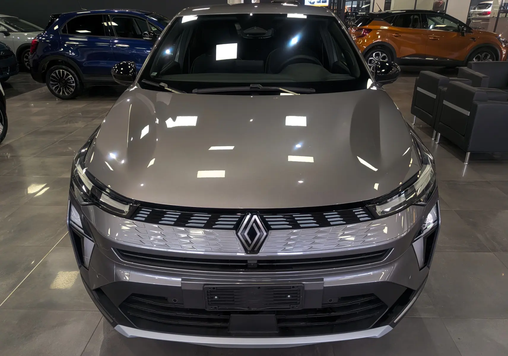 Vue avant rapprochée du Renault SYMBIOZ gris Cassiopé, soulignant sa calandre moderne et ses phares fins LED.