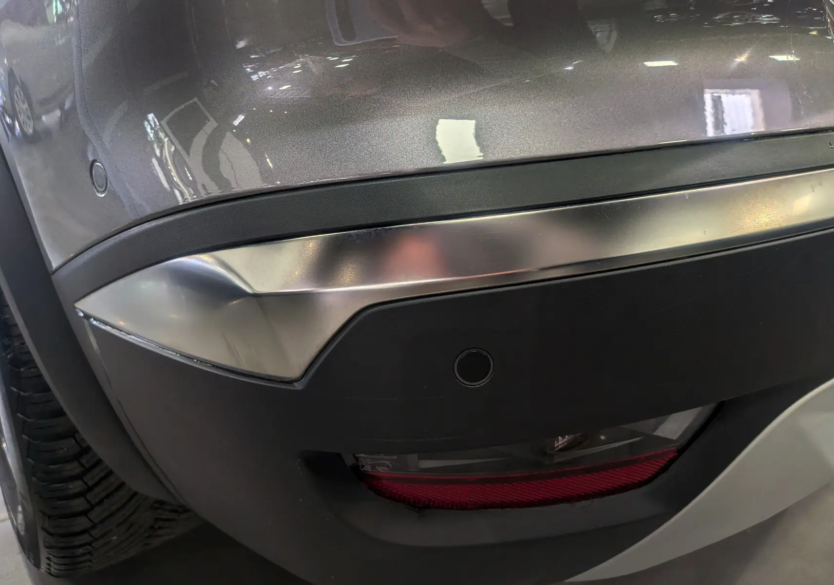 Détail du pare-chocs arrière gris Cassiopé du Renault Symbioz E-TECH, avec capteur de recul et feu antibrouillard.