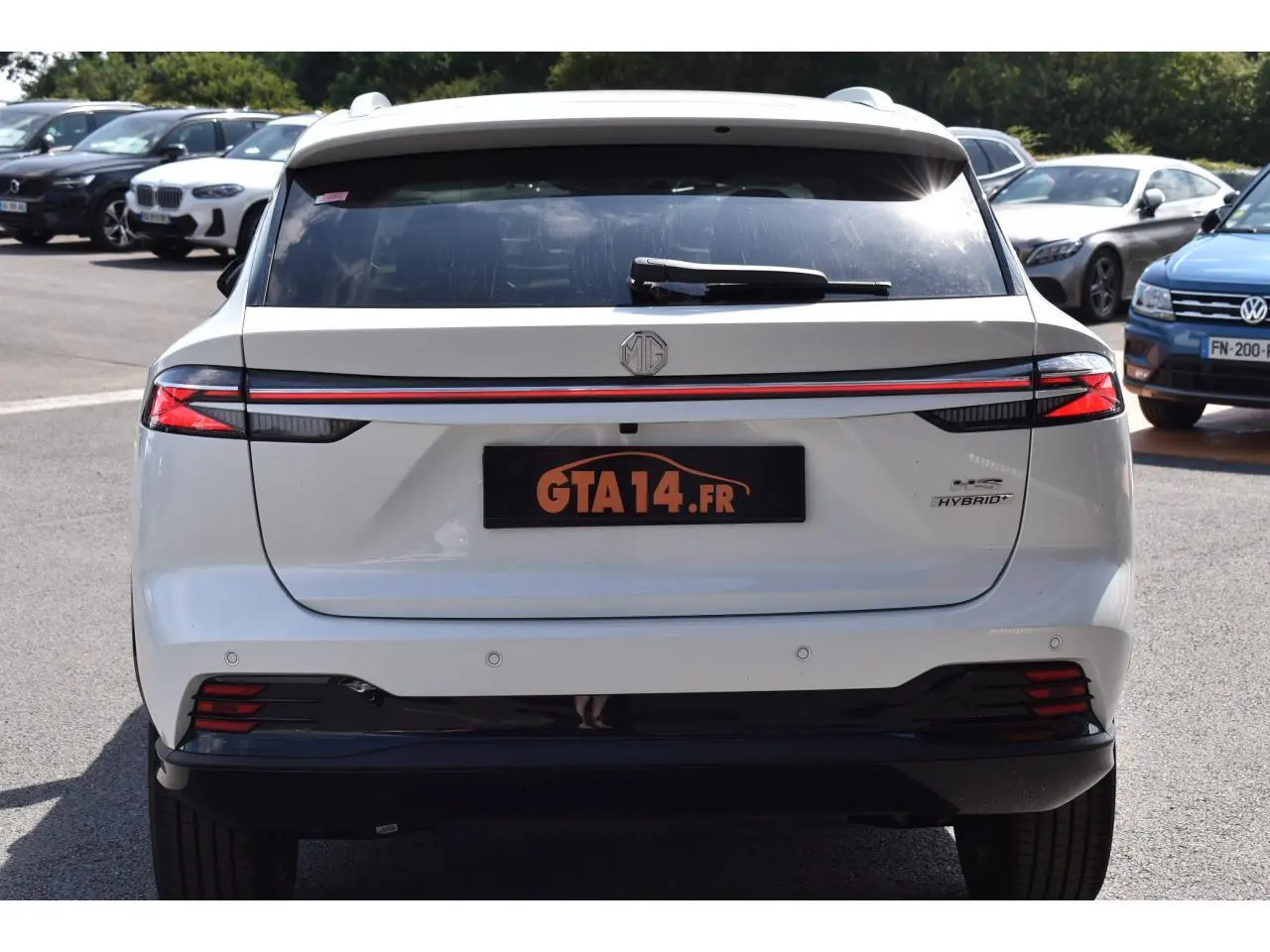 Vue arrière du MG Motor EHS blanc avec feux LED reliés par une bande rouge et logo Hybrid+ visible à droite.