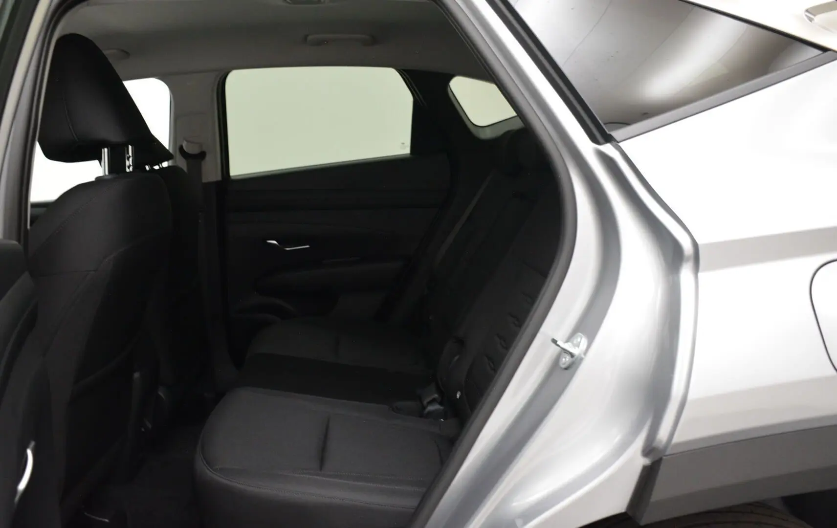 Vue intérieure côté droit sur la banquette arrière noire du Hyundai Tucson 2025 en Shimmering Silver.