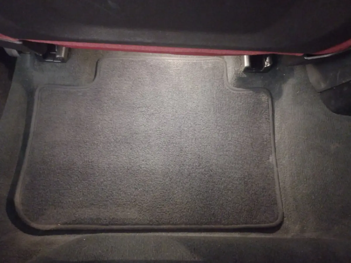 Tapis de sol noir en moquette dans l'habitacle arrière d'un BMW X3 xDrive30e blanc, vue de dessus.