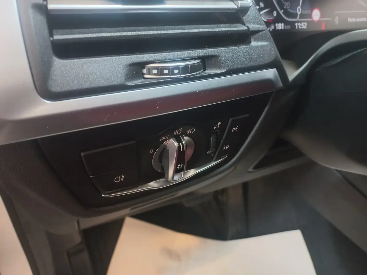 Gros plan sur le panneau de commande des phares et éclairages intérieurs dans l'habitacle du BMW X3 blanc xDrive30e.