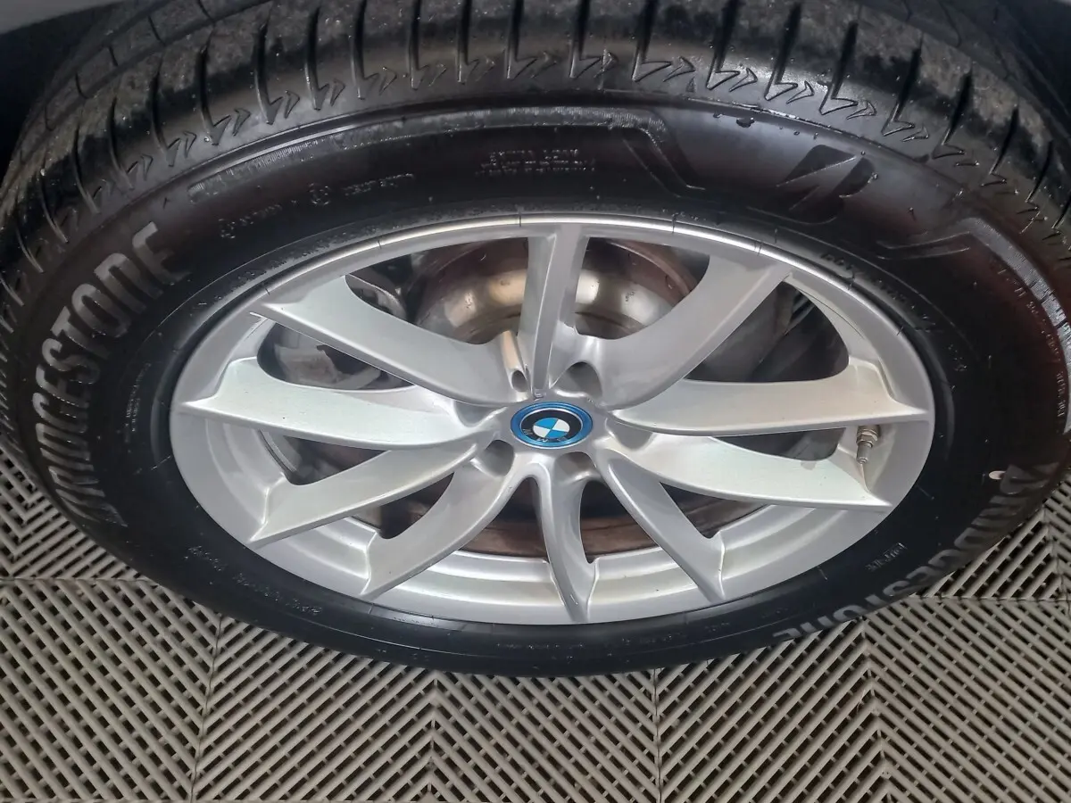 Gros plan sur la jante alliage argentée avec logo BMW au centre, montée sur pneu Bridgestone.