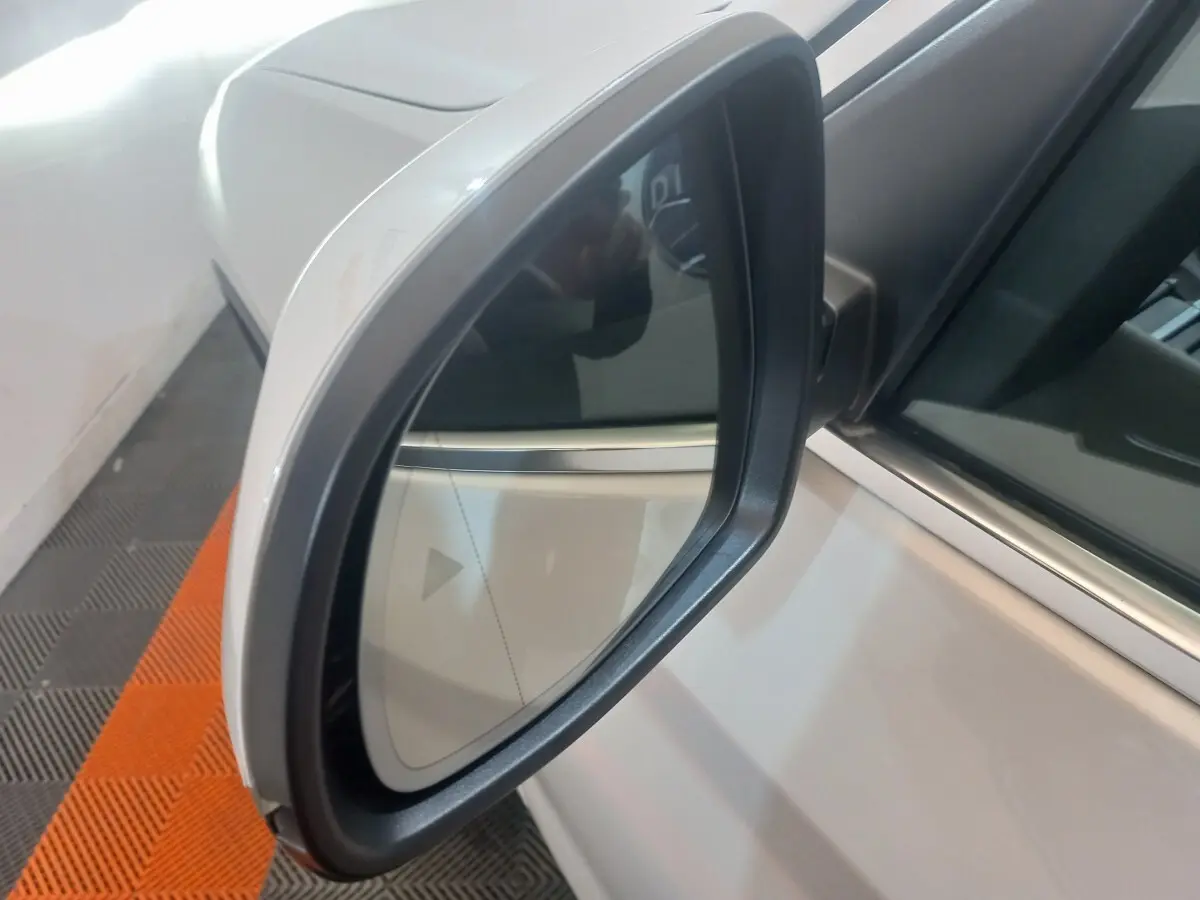 Rétroviseur extérieur côté gauche blanc du BMW X3 xDrive30e 2022 avec carrosserie visible en arrière-plan.