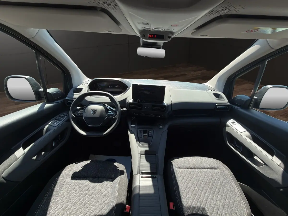 Vue intérieure avant du Peugeot Rifter 2026, tableau de bord moderne avec écran tactile central et sièges gris.