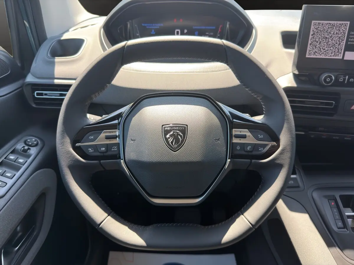 Vue rapprochée du volant cuir multifonctions du Peugeot Rifter 2026 avec tableau de bord et écran tactile visibles.