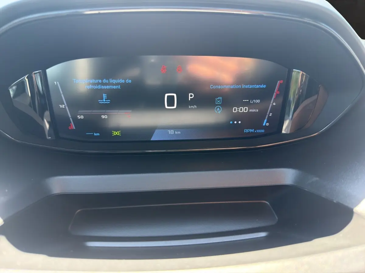 Vue rapprochée du combiné d'instruments numérique du Peugeot Rifter 2026 affichant vitesse, température et consommation instantanée.