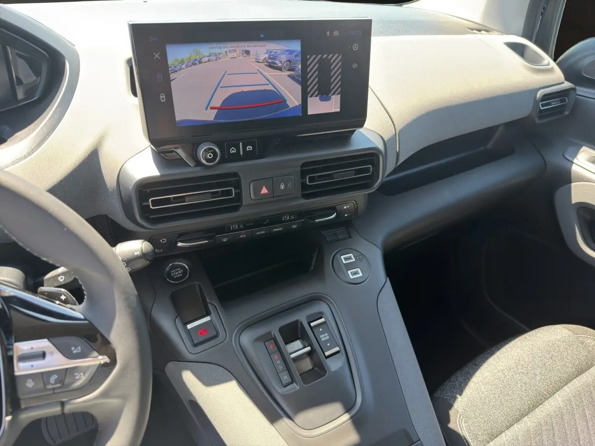 Vue intérieure du tableau de bord et console centrale du Peugeot Rifter bleu, avec écran tactile affichant la caméra de recul.