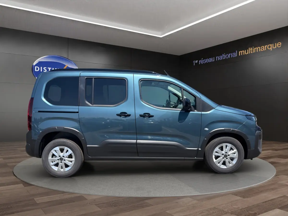 Vue latérale droite d'un Peugeot Rifter bleu 2026 avec portes coulissantes et jantes alliage.