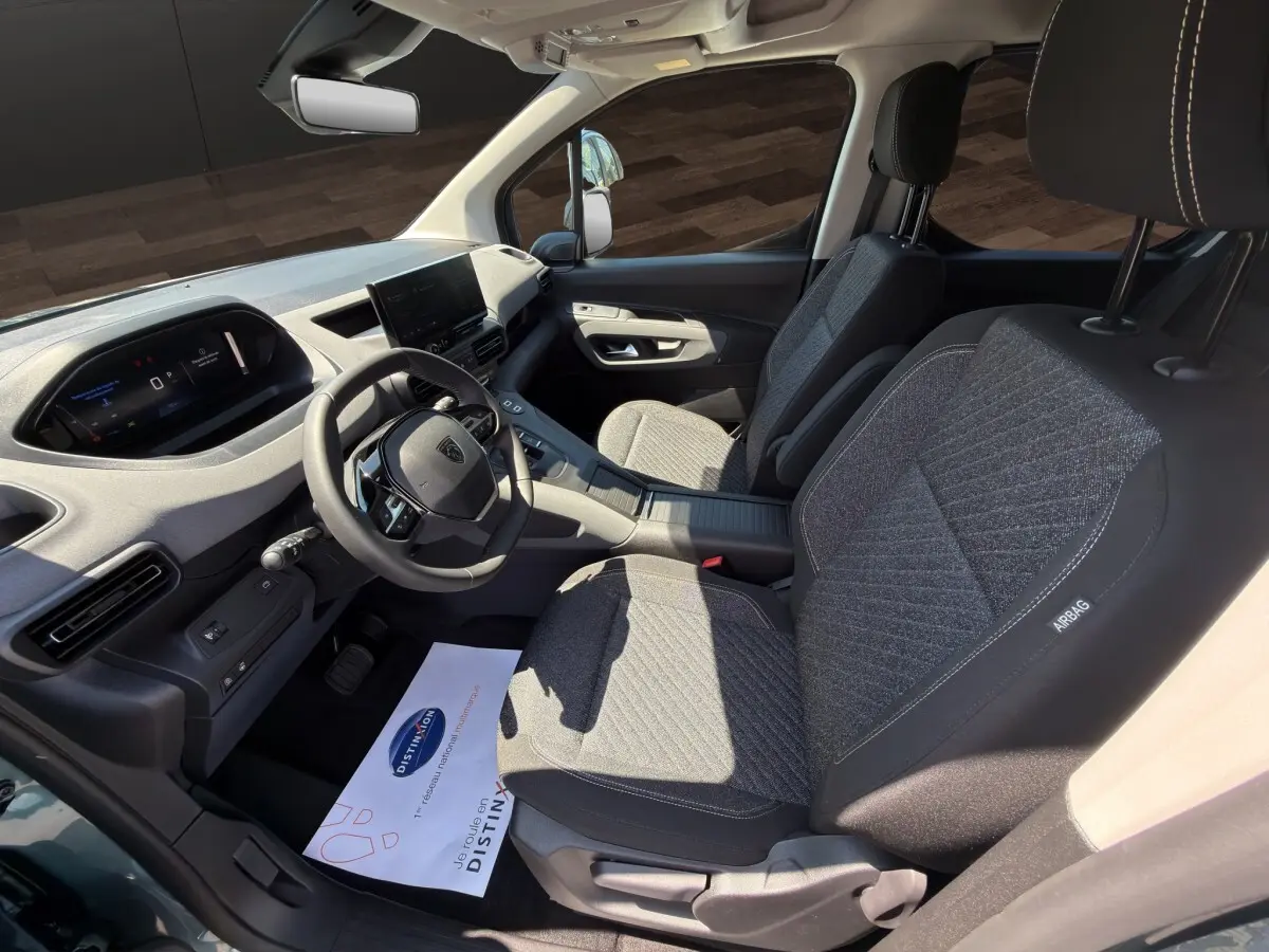 Intérieur avant du Peugeot Rifter 2026, vue côté conducteur, sièges gris et tableau de bord avec écran tactile.
