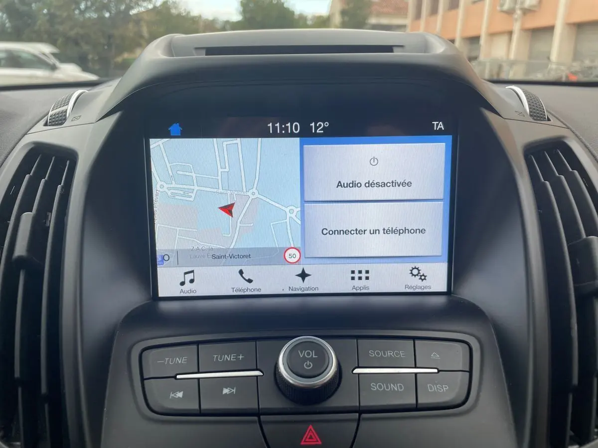 Vue rapprochée de l'écran tactile et des commandes centrales du Ford Kuga gris 2017 avec navigation affichée.
