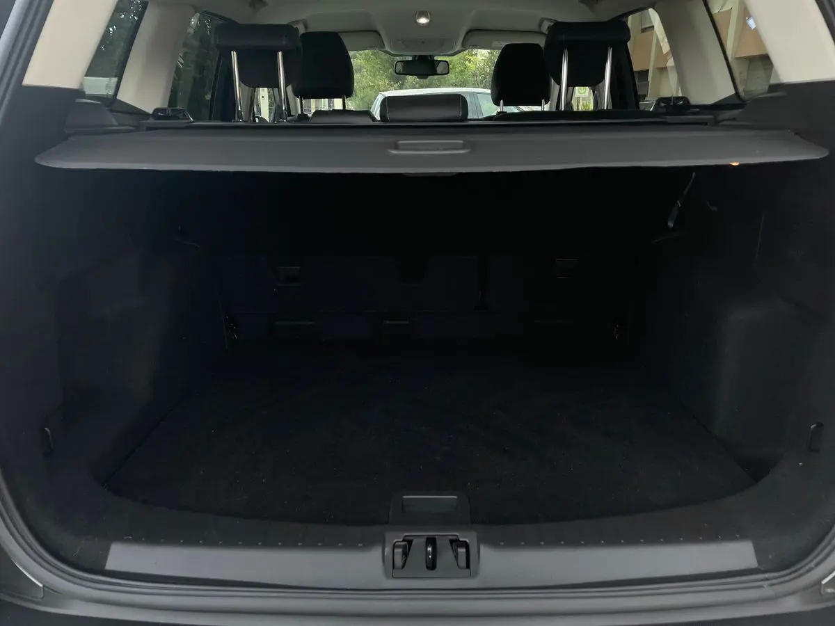 Coffre ouvert en vue arrière d'un Ford Kuga gris 2017, montrant l'espace de chargement et la plage arrière.