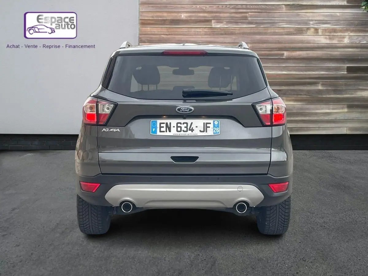Vue arrière d'un Ford Kuga gris 2017 avec double sortie d'échappement et plaque d'immatriculation française.
